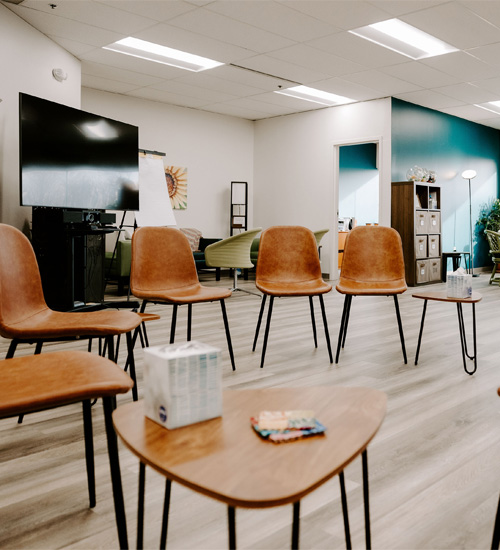 Chairs arranged in a circle in a bright room.